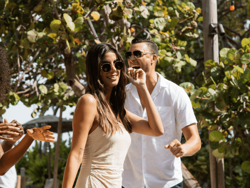 Stylish couple wearing sunglasses outside laughing