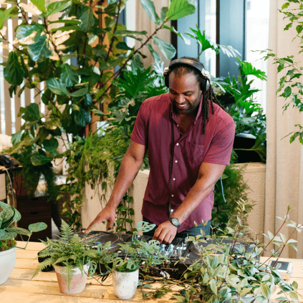 Person using a turntable with plants next to it