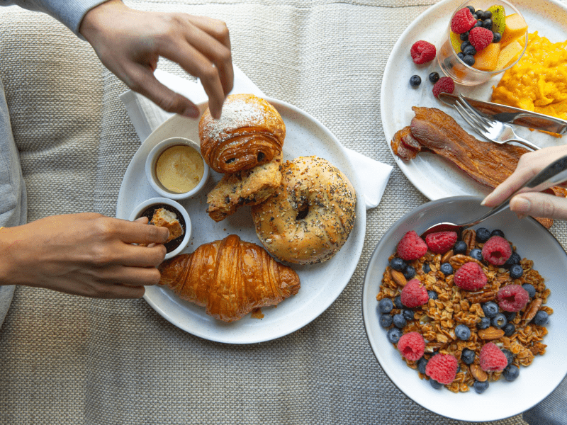 Plates with bagels, croissants, and a bowl of cereal