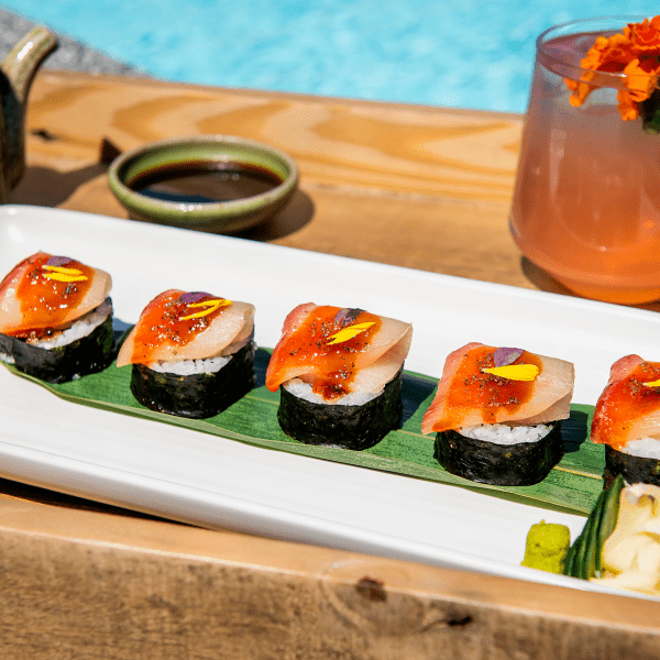 Sushi plate with cocktail by the pool