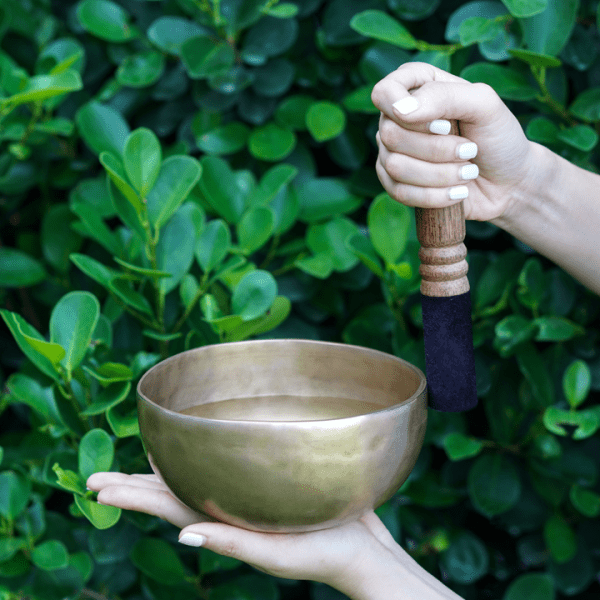 A hand holding a singing bowl
