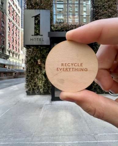 Picture from @farmernick holding a round wood piece saying "Recycle Everything" With the 1Hotels on the background  Picture from @farmernick holding a round wood piece saying "Recycle Everything" With the 1Hotels on the background
